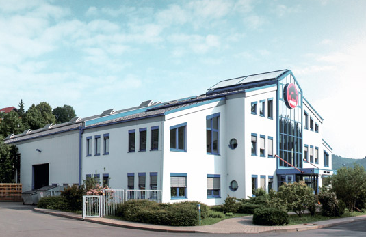 PREFA Firmengebäude mit blauen Fenstern und weißer Fassade in Wasungen, Deutschland.