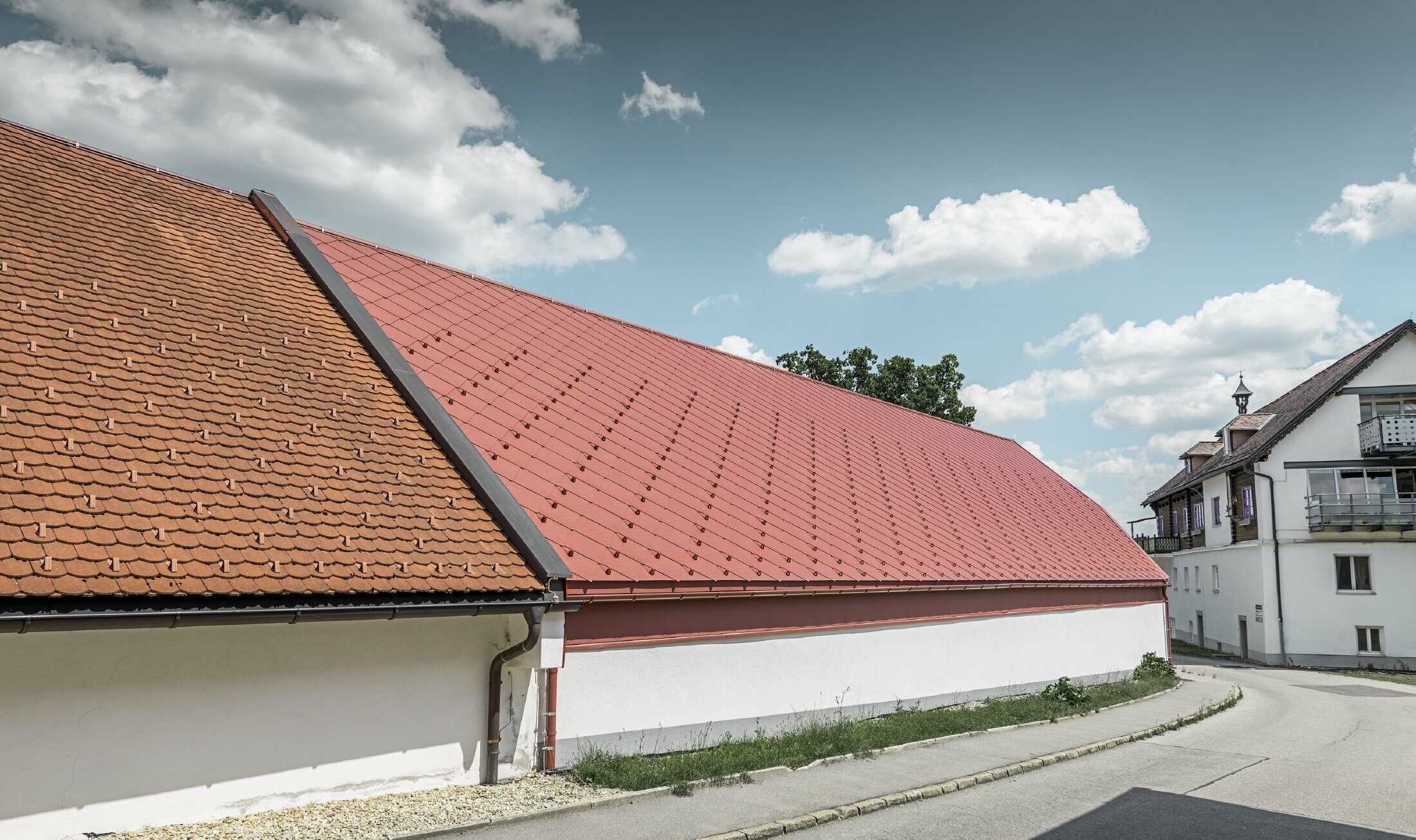 Udvendig visning af Kerzenwelt i Schlägl. Taget er belagt med den omfangsrige PREFA aluminiumrombe 44 x 44 i oxidrød.