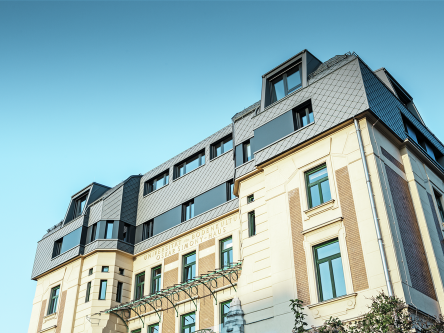 Die BOKU Wien Simonyhaus wurde von unten bei strahlendem Sonnenschein fotografiert. Das Simonyhaus wurde mit der PREFA Dachraute 29 x 29 in der Farbe P.10 Hellgrau eingedeckt.