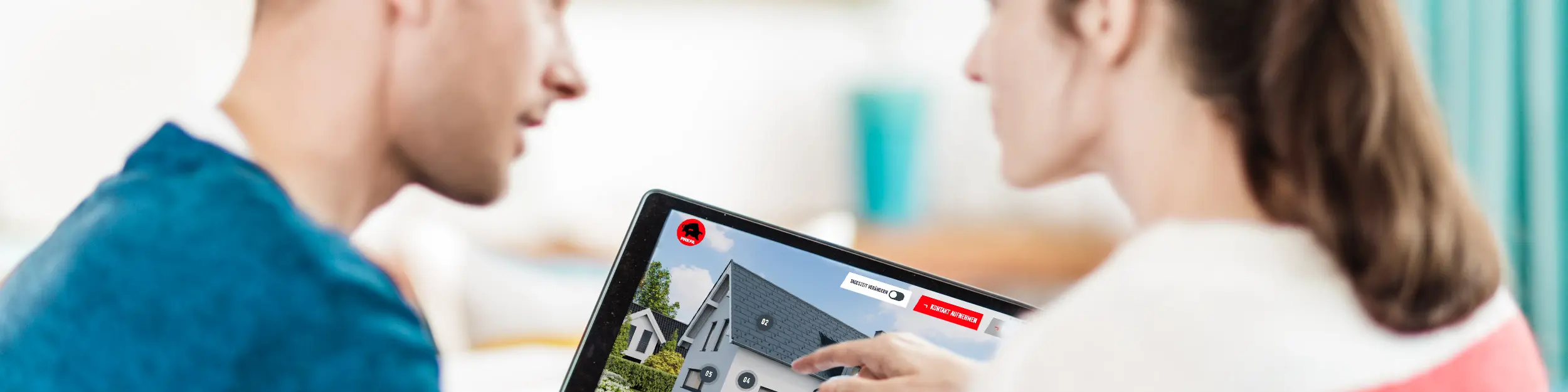 Et par sidder sammen ved bordet og kigger på den digitale visning af et hus med tag, facade og solcelleelementer af aluminium på en tavle-pc – i forbindelse med PREFA-rådgiveren til tag, facade og solceller til husbyggeri og sanering.
