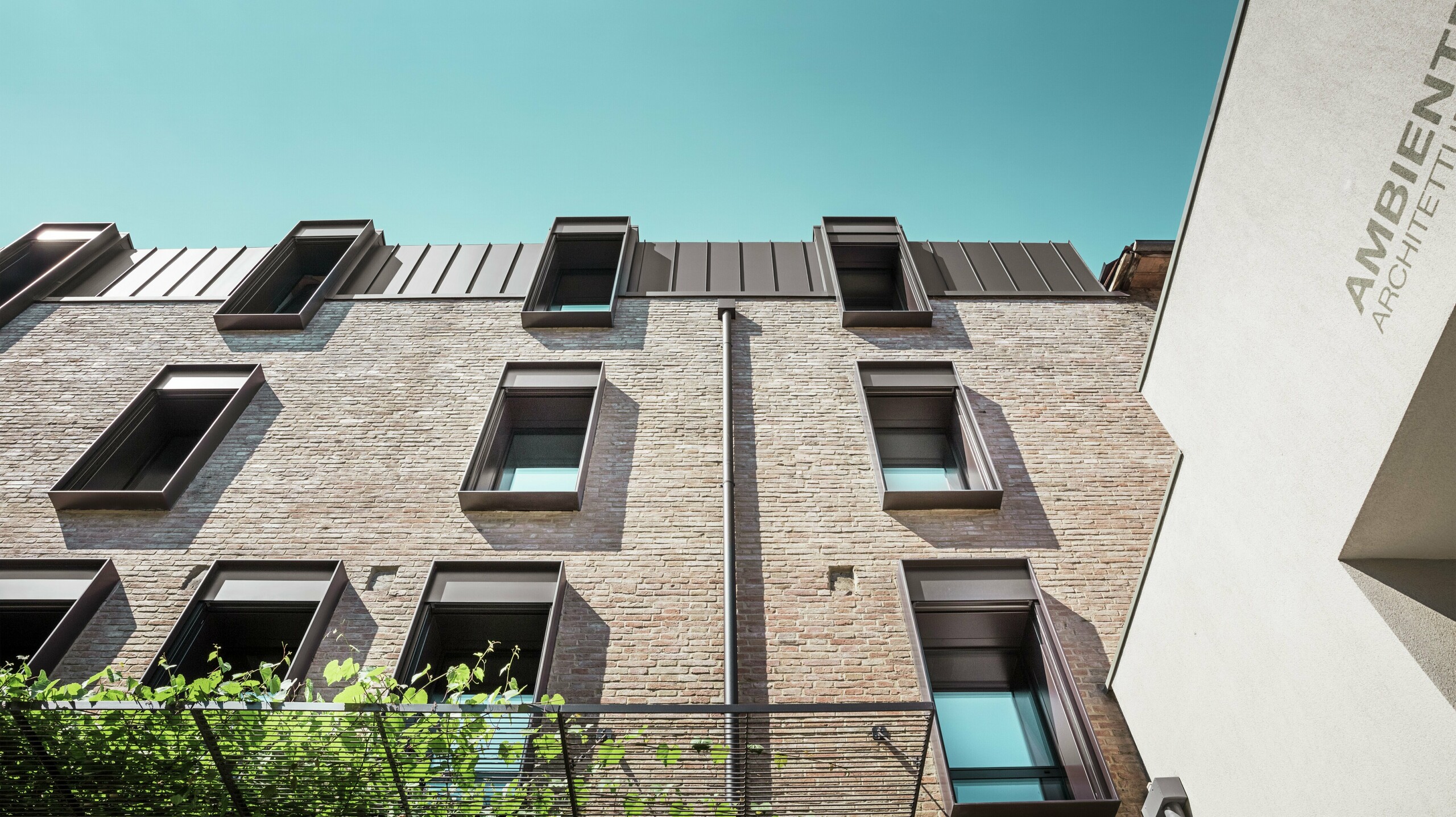 Traditionelles Backsteinhaus in Italien mit langlebigem PREFALZ Aluminiumdach in der Farbe P.10 Nussbraun – harmonische Kombination aus mediterraner Architektur und moderner Dachlösung