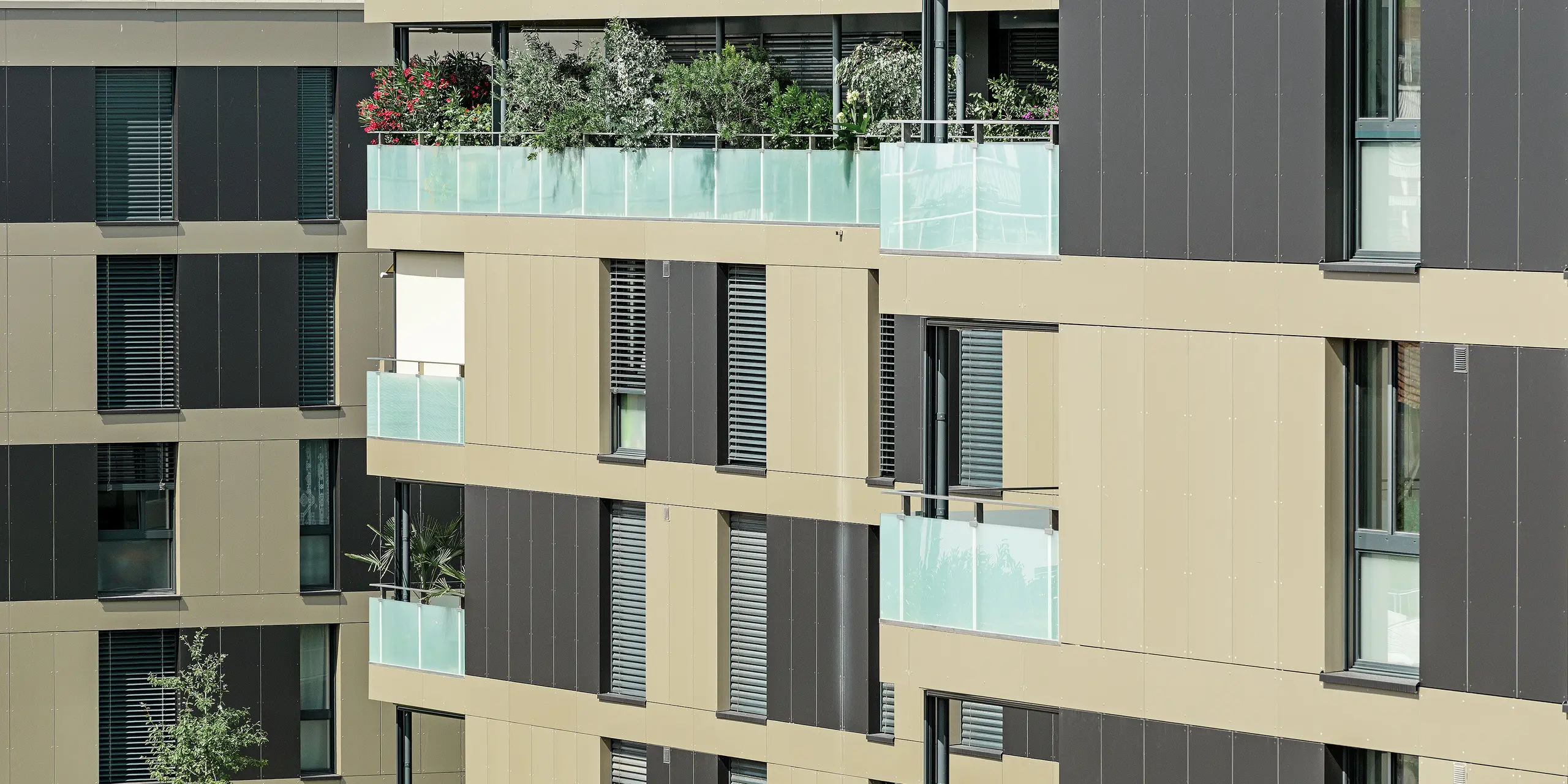 Terningformet boliganlæg med en aluminiumfacade i bronze med sortgrå elementer