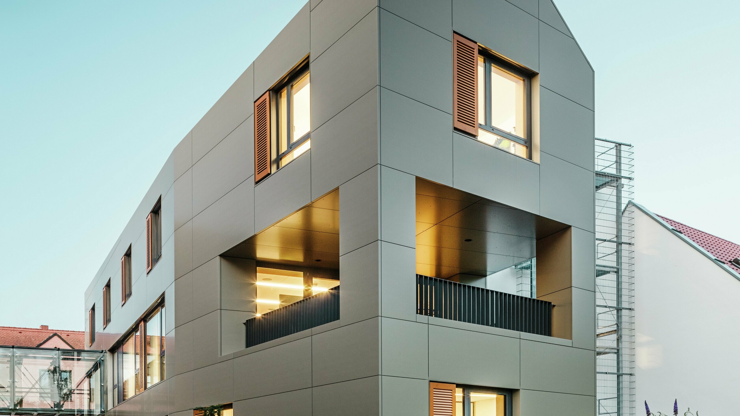 [Translate to Dansk:] Das Rathaus in Alzenau, Deutschland, zeigt eine moderne Fassade aus Aluminium-Verbundplatten von PREFA in Bronze. Die klaren, geometrischen Linien der Platten verleihen dem Gebäude einen eleganten, zeitgemäßen Look. Der gepflegte Außenbereich ergänzt die Architektur.