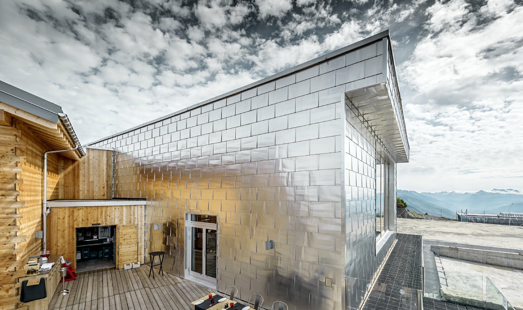 Skinnende aluminiumsfacade i naturblank aluminium på Cry D'Er Club d'Altitude i Schweiz. Facaden reflekterer den vidunderlige 360° panoramaudsigt.