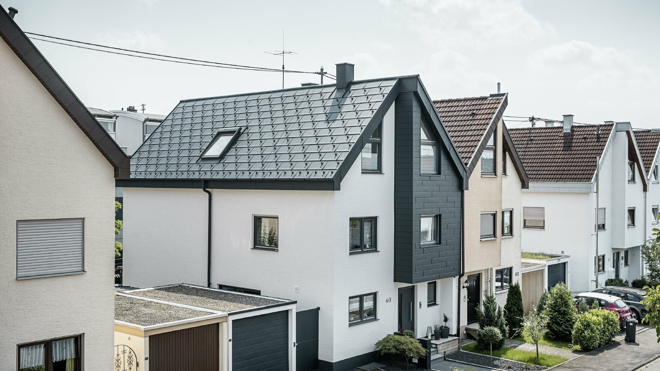 En dobbelthushalvdel blev allerede renoveret, med frisk hvid pudset facade, kombineret med en PREFA Siding.X-facade i antracit. Taget blev beklædt med PREFA-tagplade R.16. Tagafvandingen sker via den firkantede tagrende inklusive PREFA-nedløbsrør.