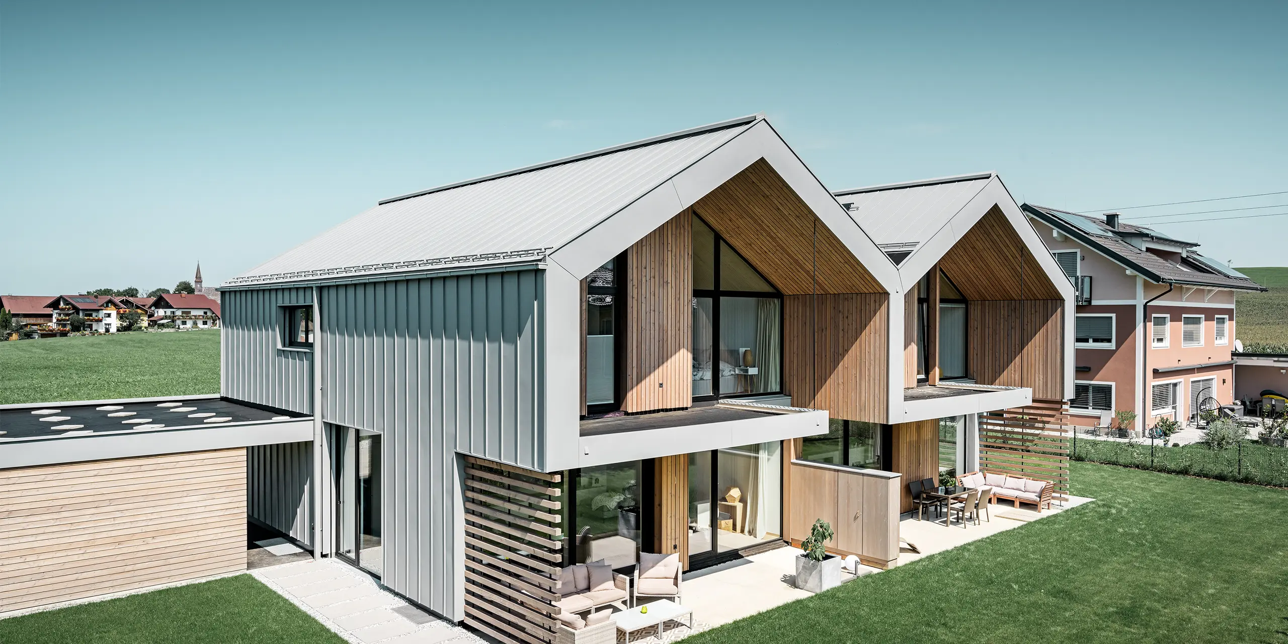 moderne dobbelthuse med PREFALZ-klimaskærm, -tag og -facade er beklædt med PREFALZ i patinagrå inklusiv kvadratrør