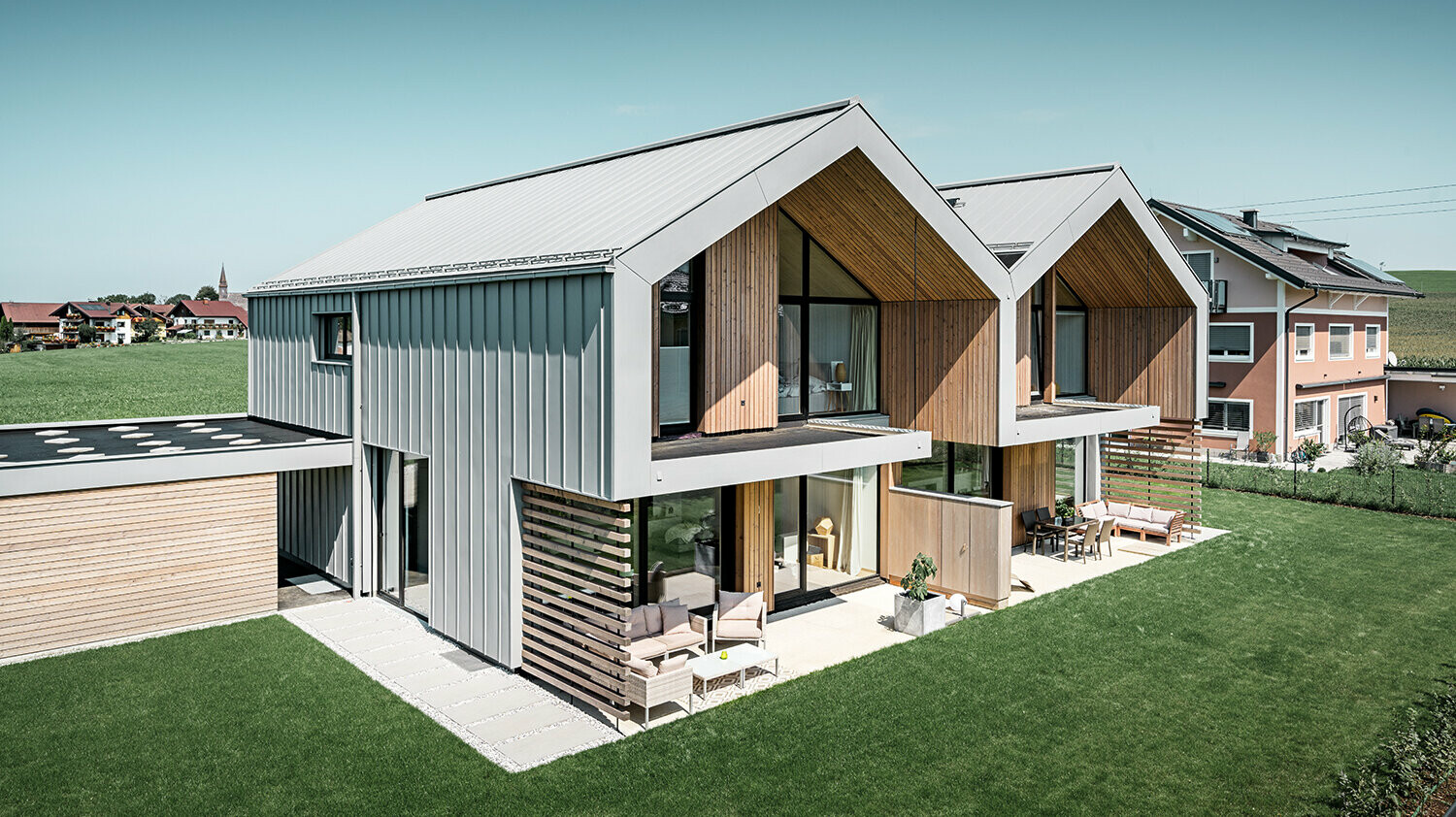 moderne dobbelthuse med PREFALZ-klimaskærm, -tag og -facade er beklædt med PREFALZ i patinagrå inklusiv kvadratrør