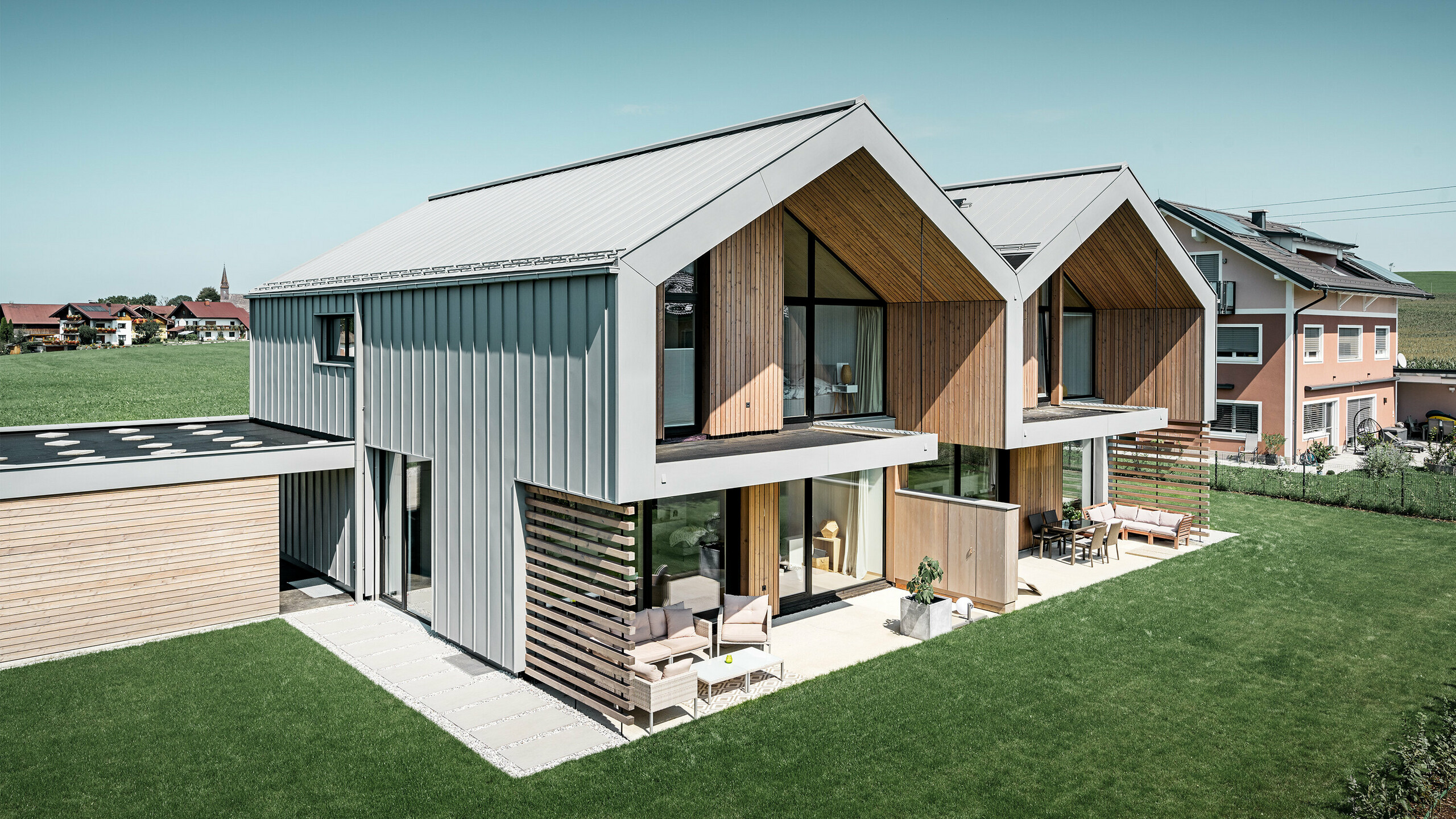 moderne dobbelthuse med PREFALZ-klimaskærm, -tag og -facade er beklædt med PREFALZ i patinagrå inklusiv kvadratrør