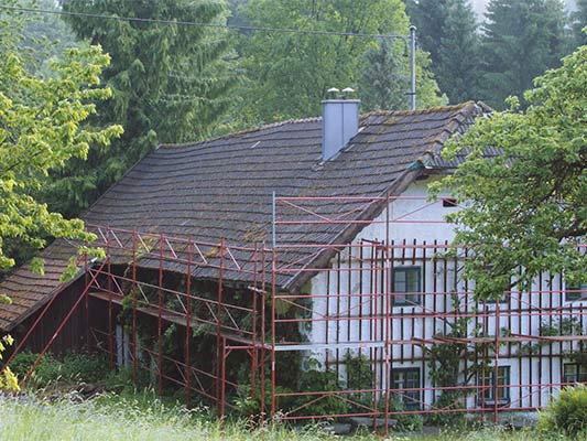 Det gamle tag på hytten lige inden renoveringen med PREFA tagspån (med stillads)